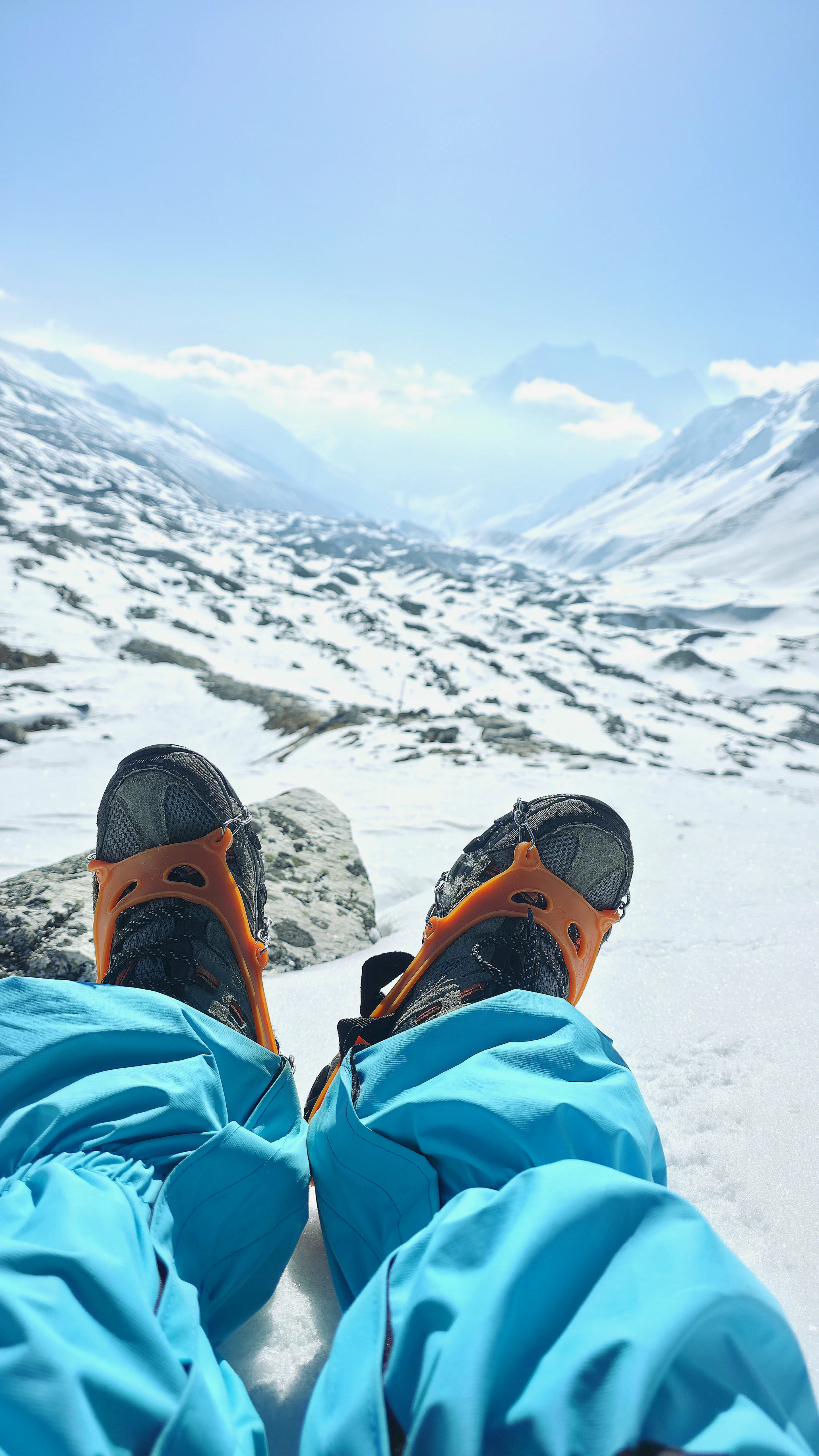 Trail shoes resting on snow, with a mountain valley beyond